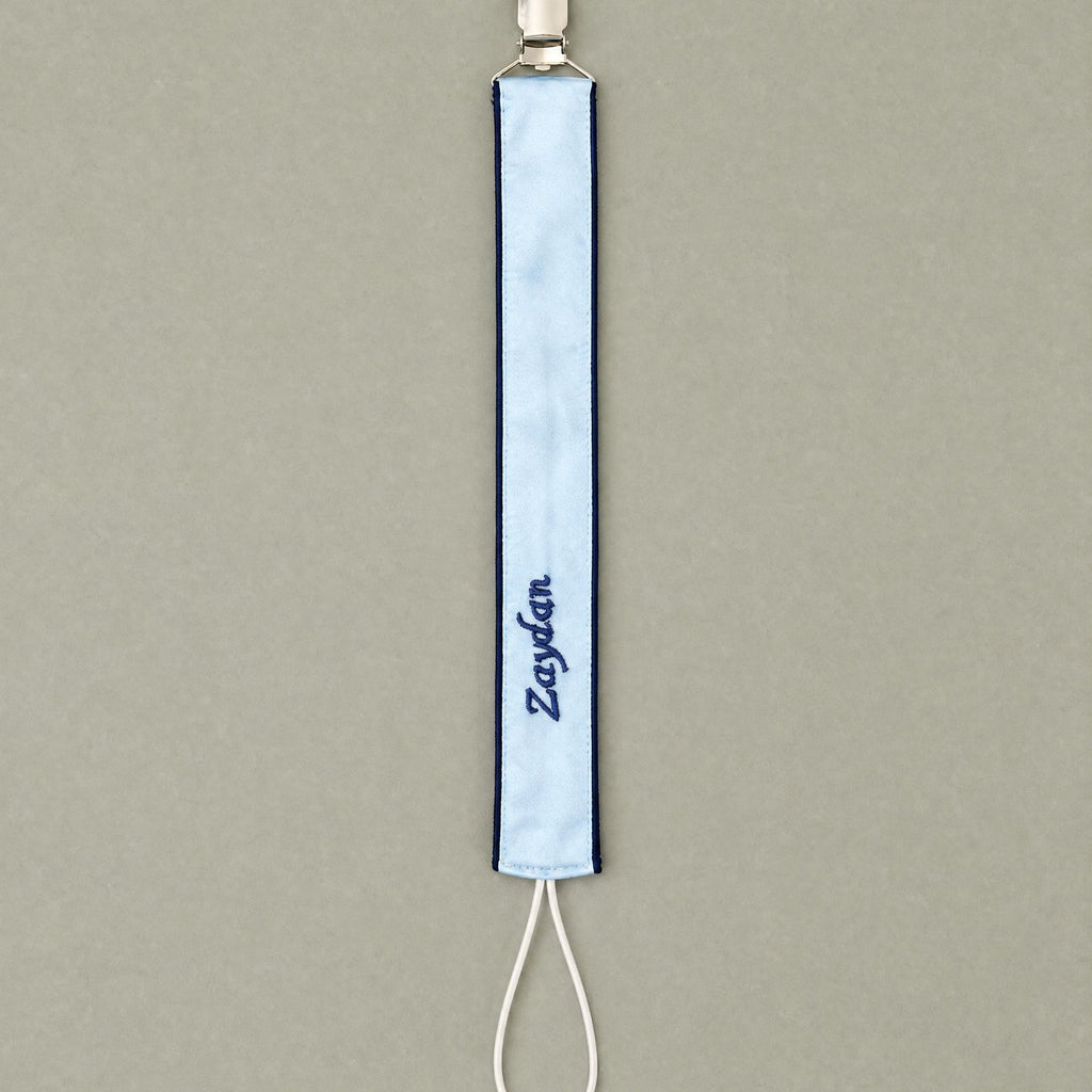 Ice blue silk pacifier holder styled in a nursery setting