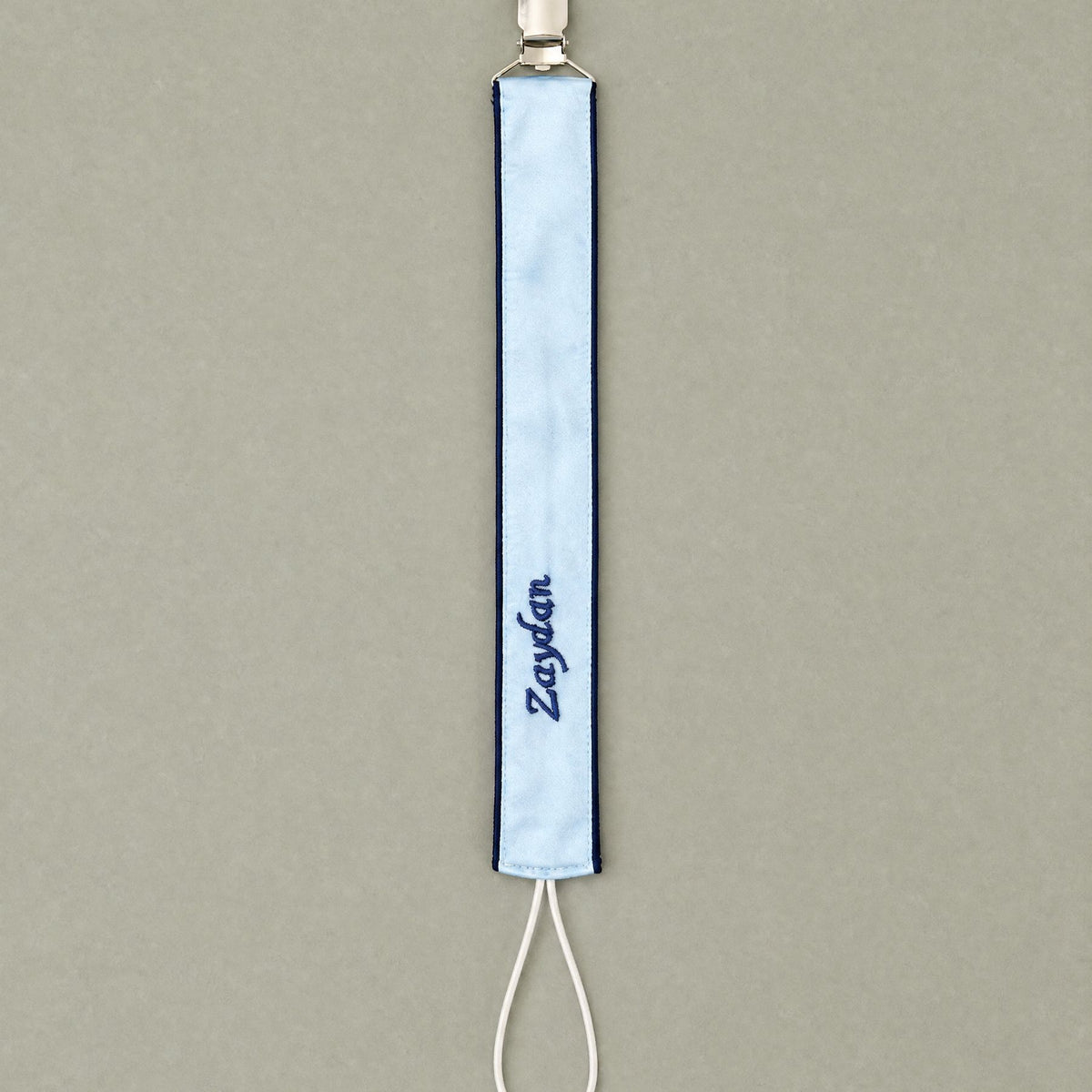 Ice blue silk pacifier holder styled in a nursery setting