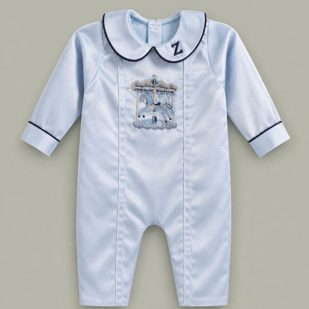 Ice blue silk baby romper with navy piping, an embroidered initial on the Peter Pan collar and a carousel motif with gold canopy at the chest