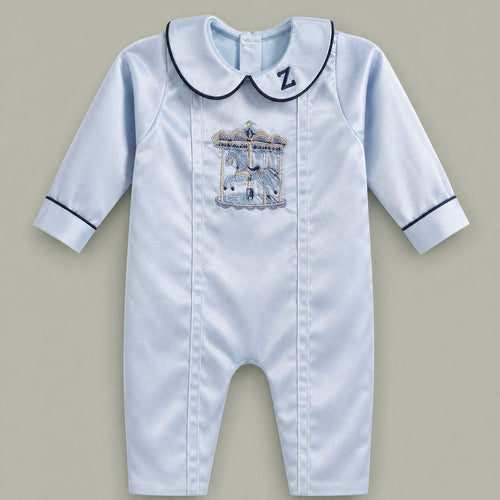 Ice blue silk baby romper with navy piping, an embroidered initial on the Peter Pan collar and a carousel motif with gold canopy at the chest