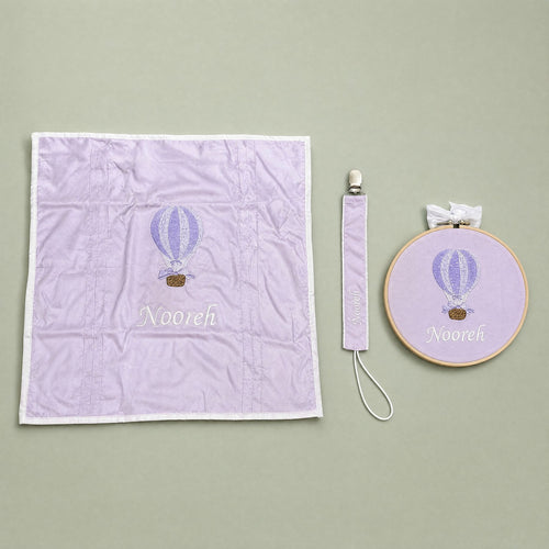 Just the Essentials lilac gift bundle laid out flat — personalised lilac silk wrapping sheet, name frame and pacifier holder