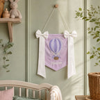 Personalised lilac silk name flag hanging on a nursery wall