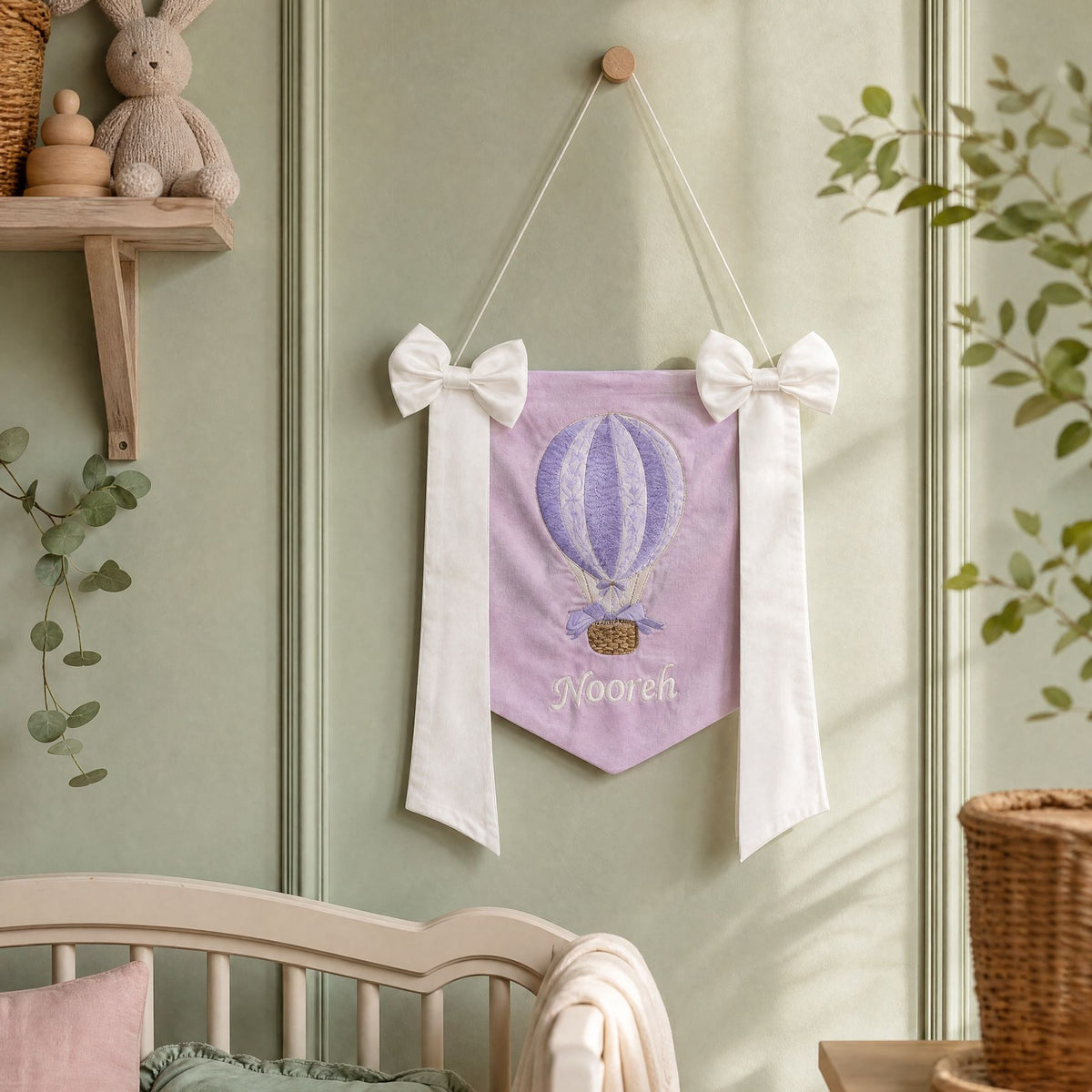 Personalised lilac silk name flag hanging on a nursery wall