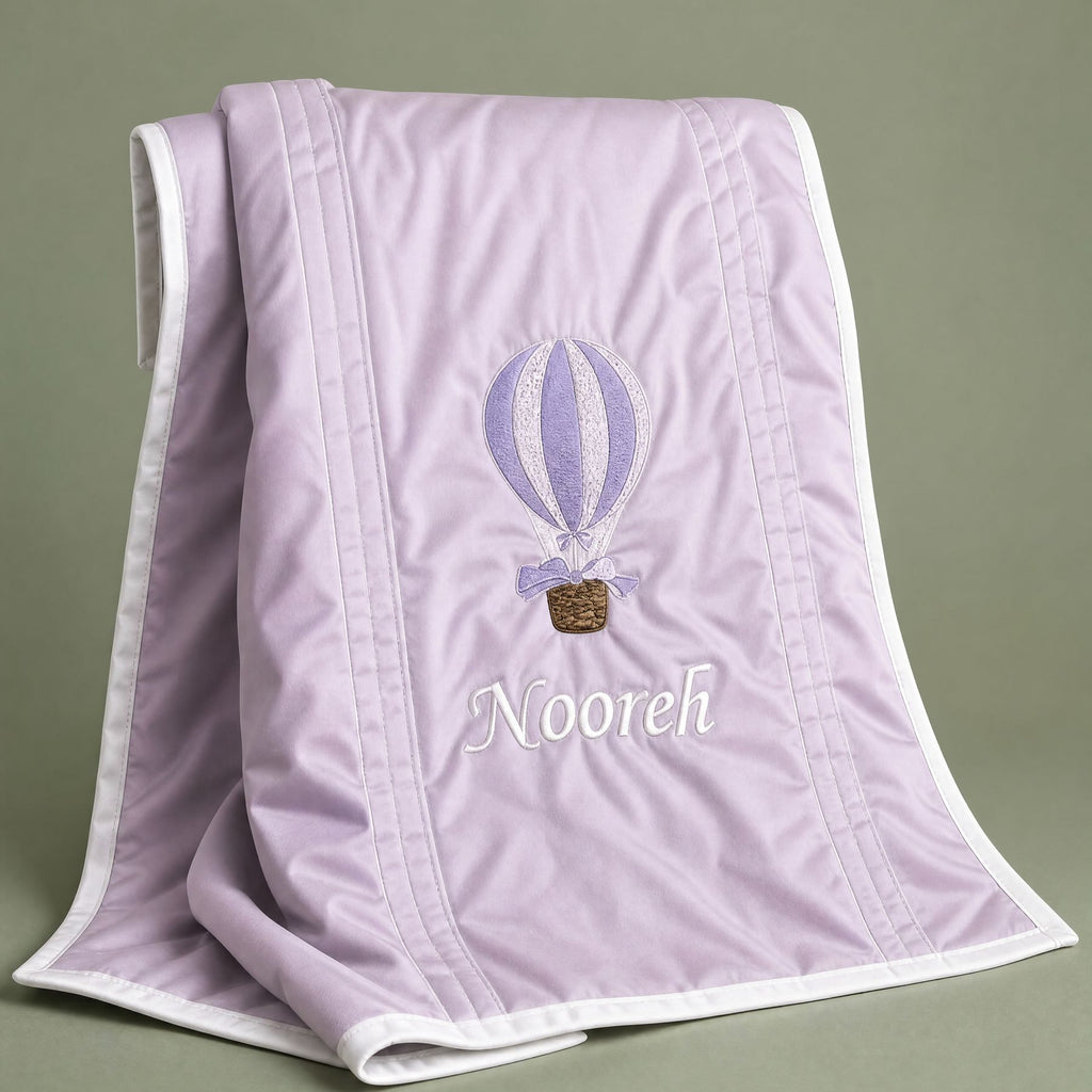 Lilac silk baby wrapping sheet with ivory trim, an embroidered hot air balloon and a name in ivory script