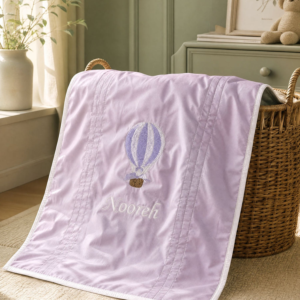 Lilac silk wrapping sheet with ivory detailing, styled in a nursery setting