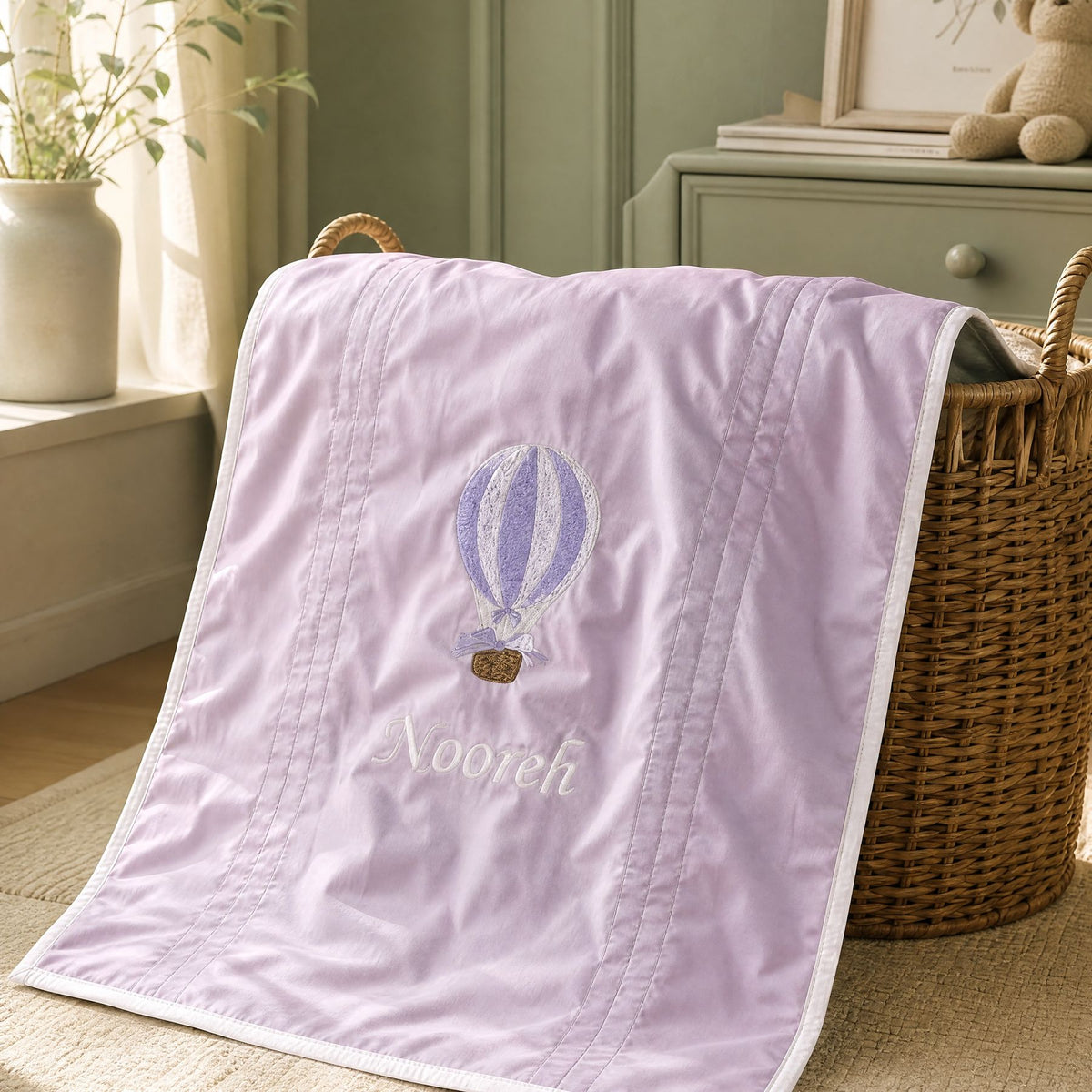 Lilac silk wrapping sheet with ivory detailing, styled in a nursery setting
