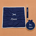 Just the Essentials navy gift bundle laid out flat — personalised silk wrapping sheet, name frame and pacifier holder