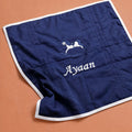 Navy silk baby wrapping sheet with ivory satin binding, an embroidered rocking horse and a name embroidered in ivory script