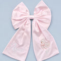 Large soft pink silk announcement bow with a baby's name in ivory on one tail and an embroidered swan with It's a girl on the other