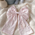 Personalised pink silk announcement bow styled for a new baby girl announcement