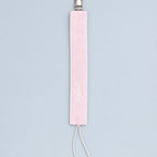 Soft pink silk pacifier holder with white edging, a metal clip, ivory cord loop and a baby's name embroidered in ivory script
