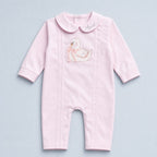 Soft pink silk baby romper with a Peter Pan collar, tonal piping and an embroidered white swan with a pink ribbon bow at the chest