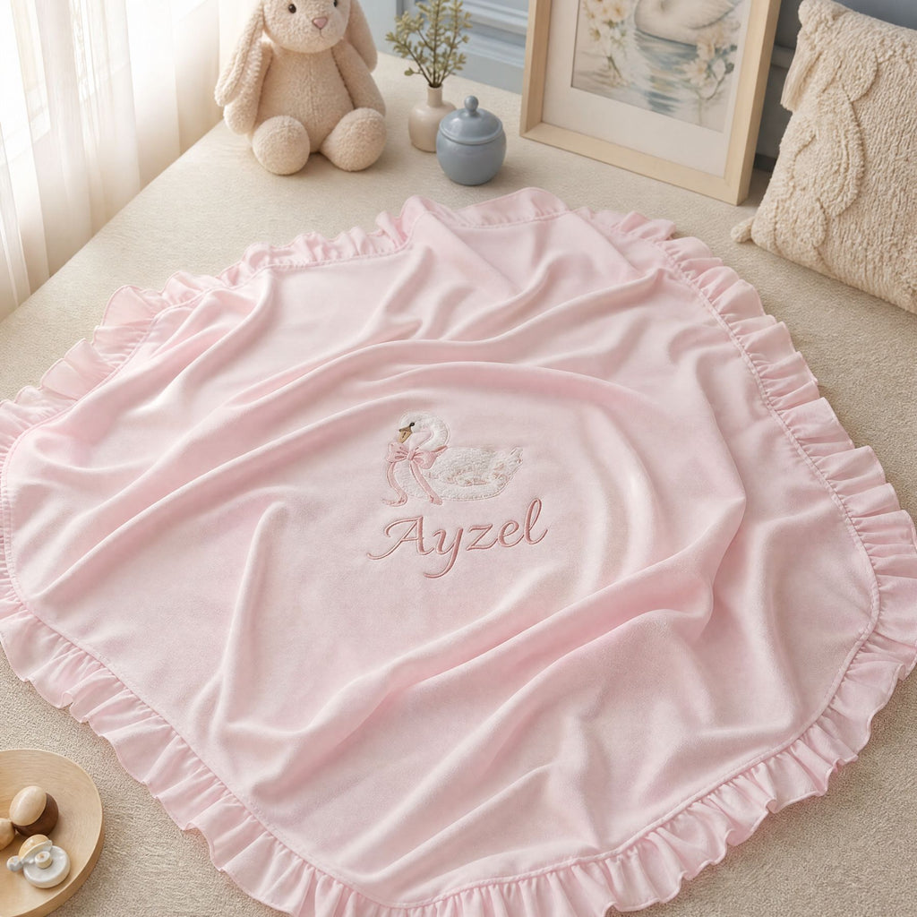 Pink quilted silk wrapping sheet with swan embroidery, styled in a nursery setting