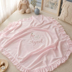 Pink quilted silk wrapping sheet with swan embroidery, styled in a nursery setting