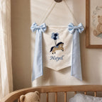 Personalised ivory silk name flag hanging on a nursery wall