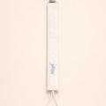 Ivory silk pacifier holder with pale blue detailing and a baby's name embroidered in pale blue script