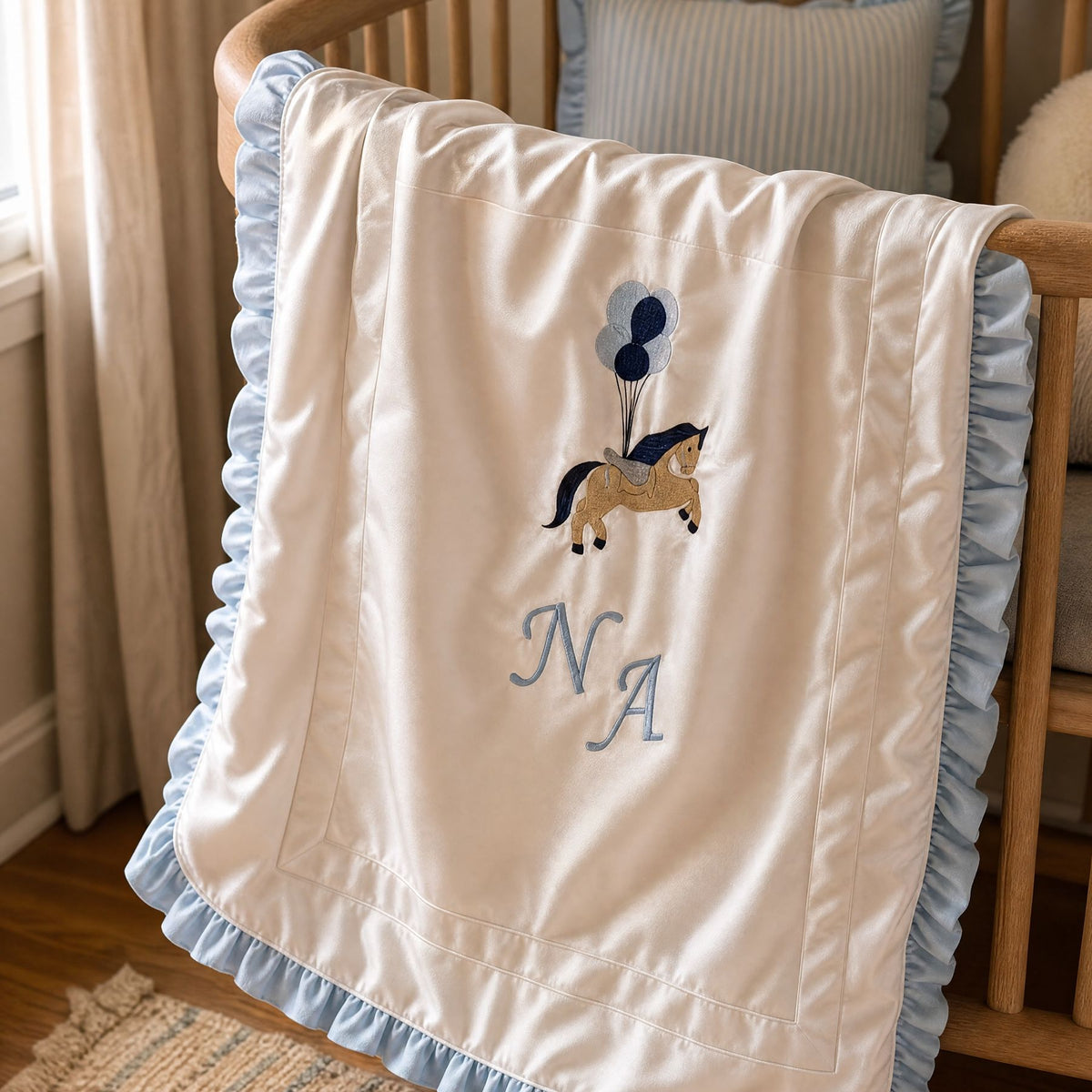 Ivory silk wrapping sheet with pale blue detailing, styled in a nursery setting