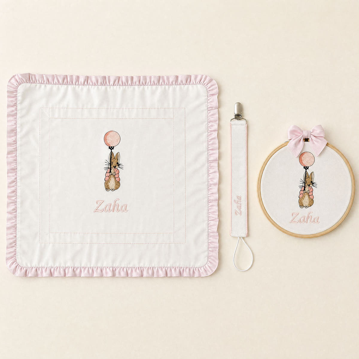 Just the Essentials white and pink gift bundle laid out flat — personalised ivory silk wrapping sheet, name frame and pacifier holder