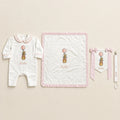 Welcome to the World white and pink gift bundle laid out flat — personalised ivory silk romper, wrapping sheet, name flag and pacifier holder