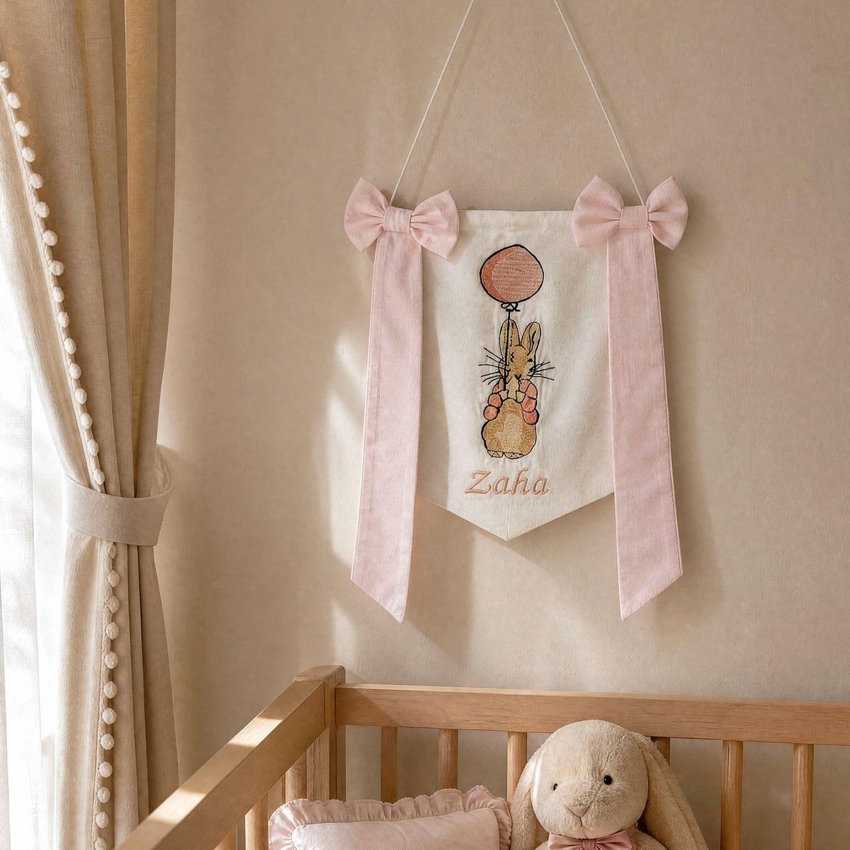 Personalised white and pink silk name flag hanging on a nursery wall