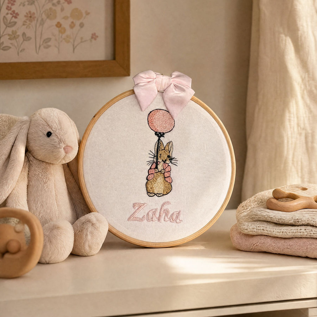 Personalised white and pink name frame styled on a nursery wall