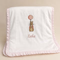 Quilted ivory silk baby wrapping sheet with a soft pink ruffle trim, an embroidered bunny with a pink balloon and a name in pink script