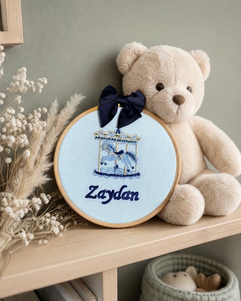 Personalised ice blue name frame on a nursery shelf beside a teddy bear